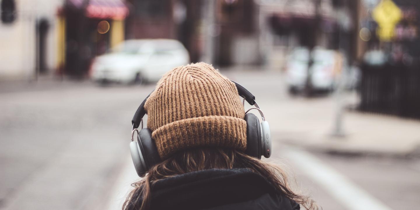 Person with headphones on over a beanie 