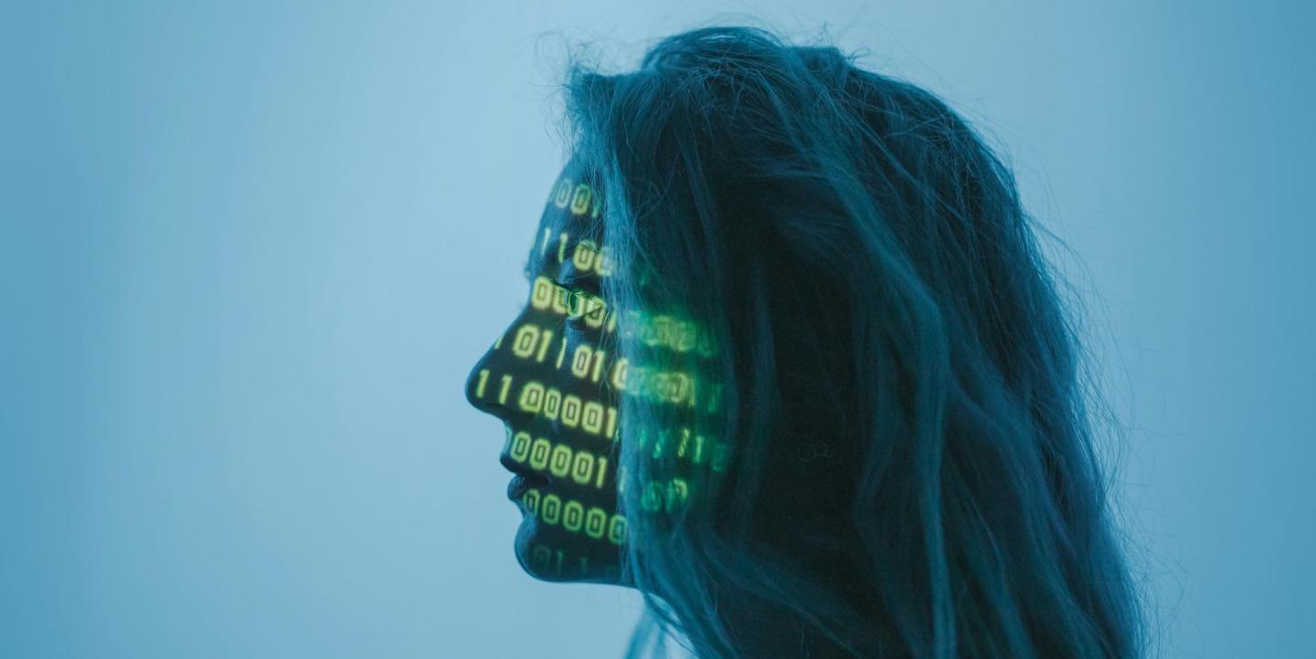 Mujer con números binarios proyectados sobre su rostro