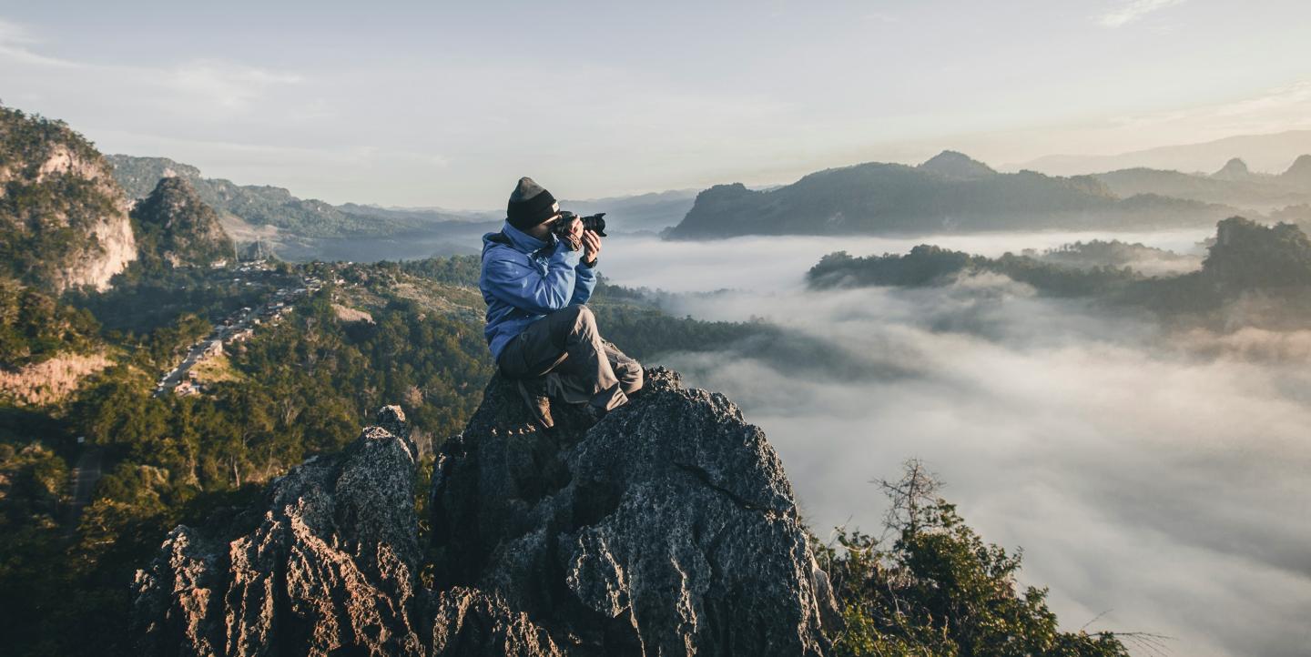 A person taking a photo on a mountain.