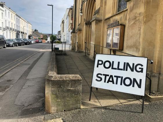 Sign reading polling station beside a street