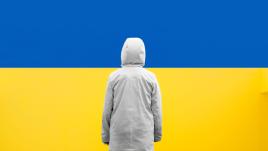 شخص يقف أمام علم أوكرانيا