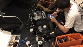 Журналист собирает аппаратуру для новостной съемки