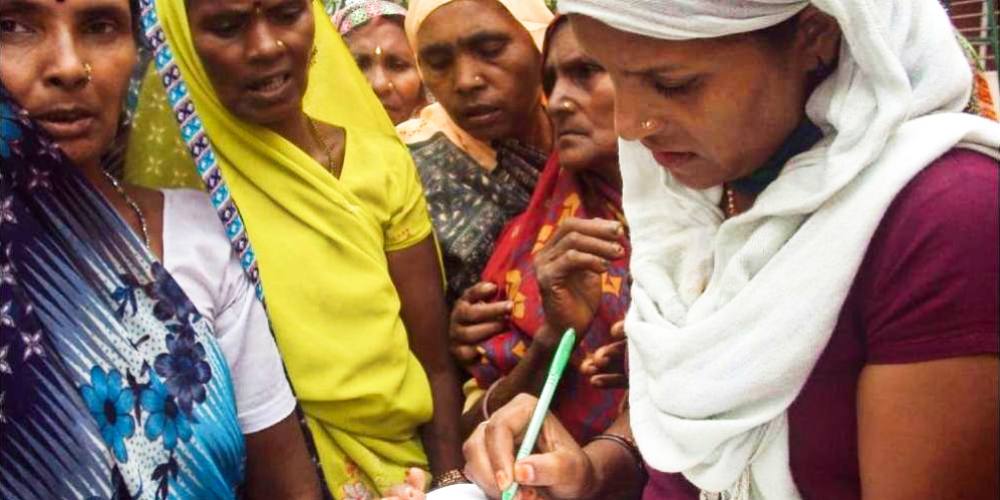 A reporter for Khabar Lahariya interviews a group of women