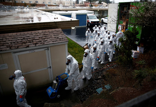 Servpro cleaning crew workers file in to begin a third day of cleaning at Life Care Center of Kirkland, a long-term care facility linked to several confirmed coronavirus cases, in Kirkland, Washington (credit: REUTERS/Lindsey Wasson). 