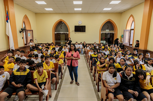 Lucero standing in the middle of a group of students.