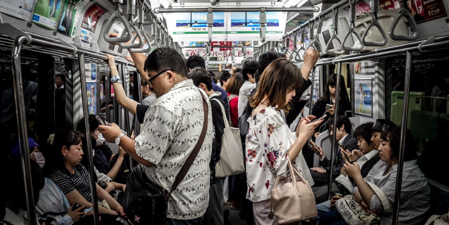 Des personnes dans le métro, beaucoup lisent sur leur téléphone