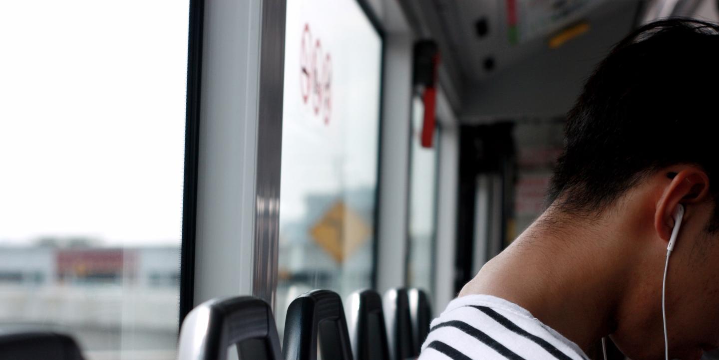 Une femme écoute un podcast dans un bus 