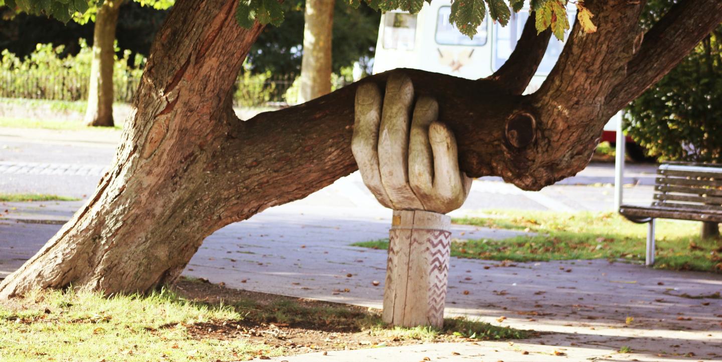 Árvore apoiada por escultura