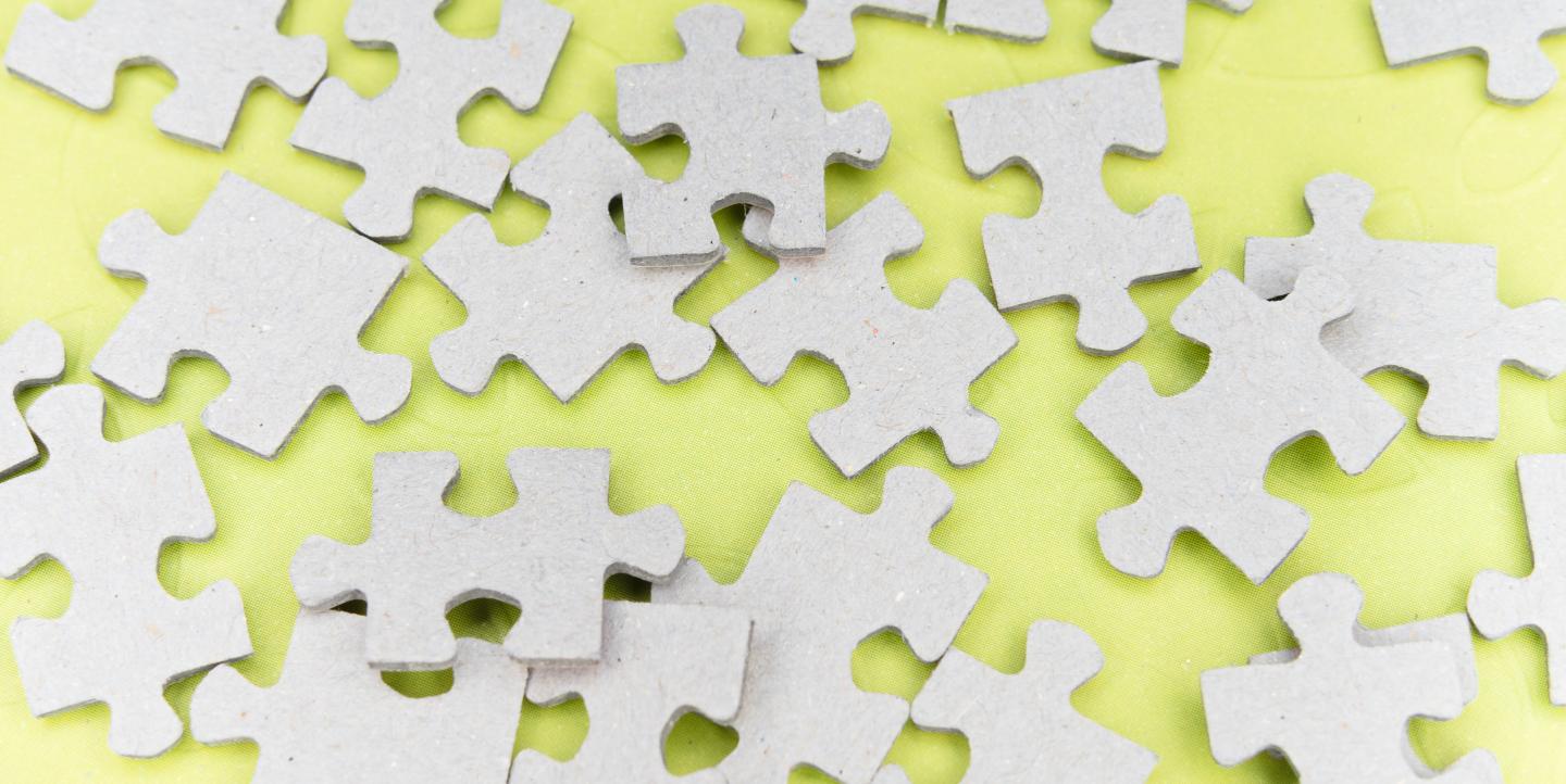 Grey puzzle pieces on a yellow background