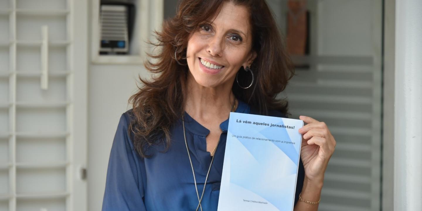 Teresa Cristina Machado posa segurando seu livro