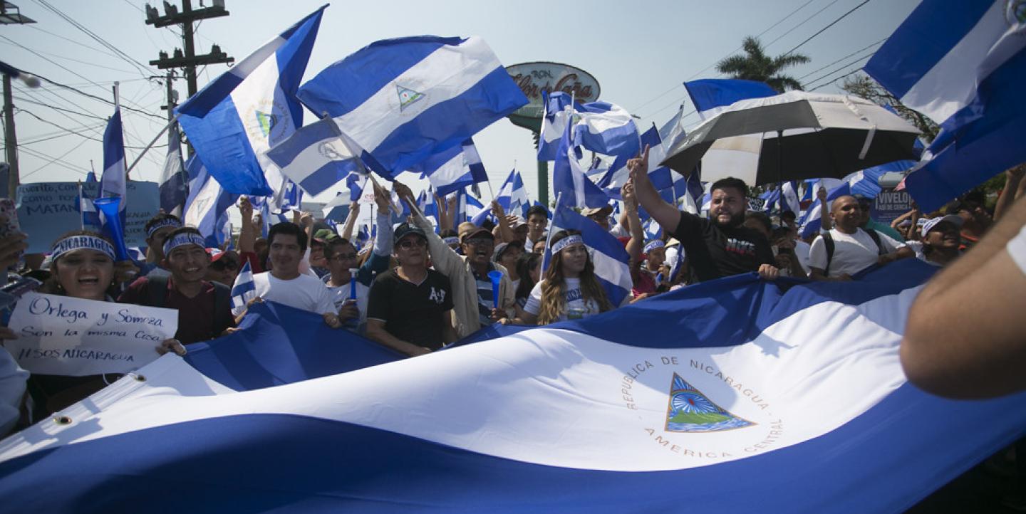 pessoas em protesto com bandeiras da nicarágua