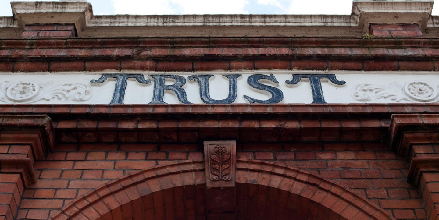 تصویری از نمای ساختمانی که روی آن واژه «اعتماد» به چشم می خورد، تصویر از پوینتر