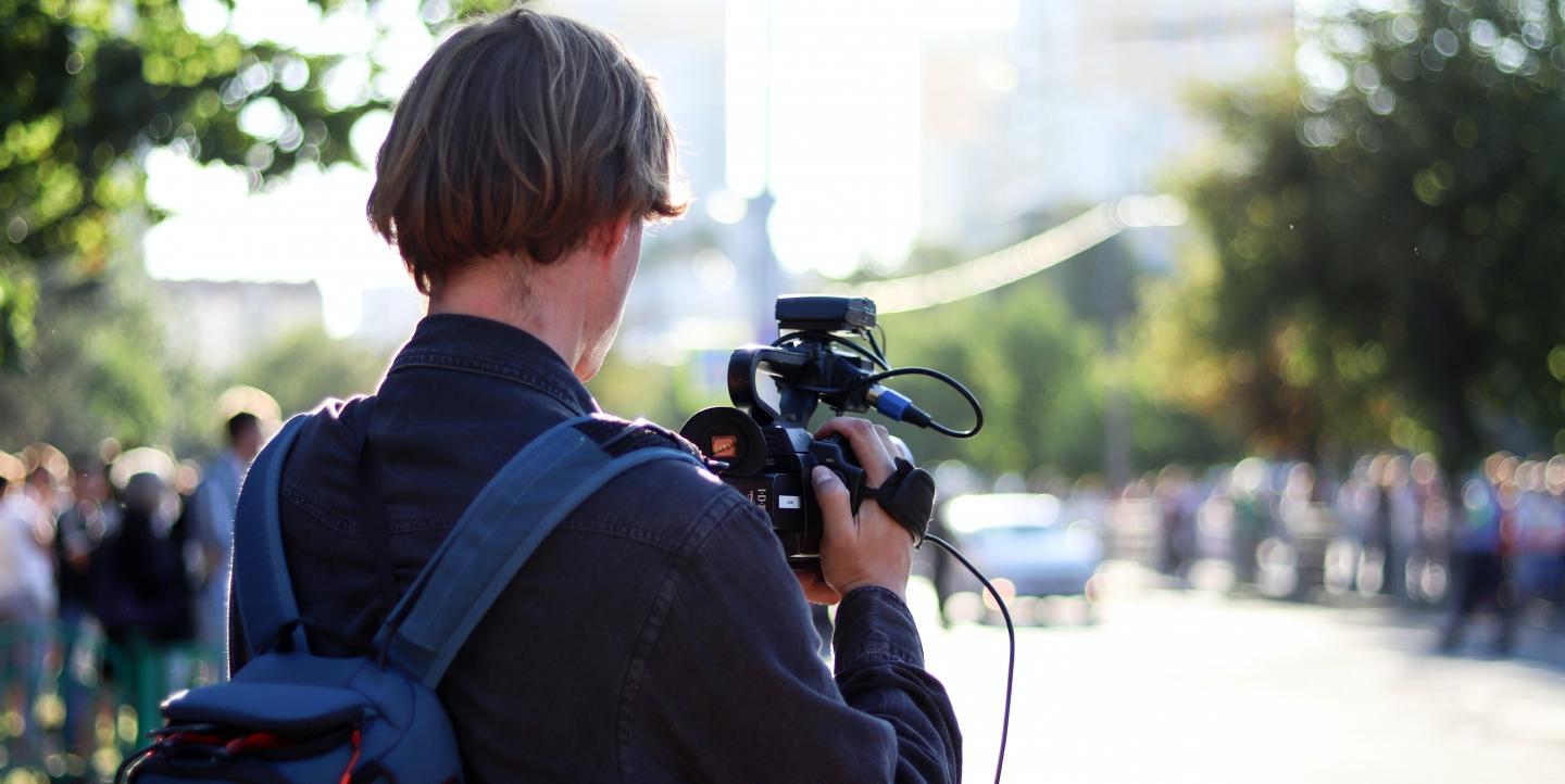 An image of the back of a person who is shooting video