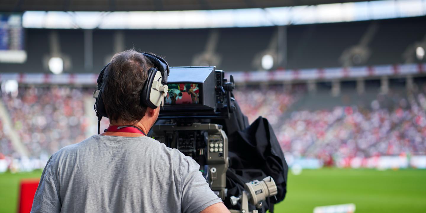 Man filming a sports event.