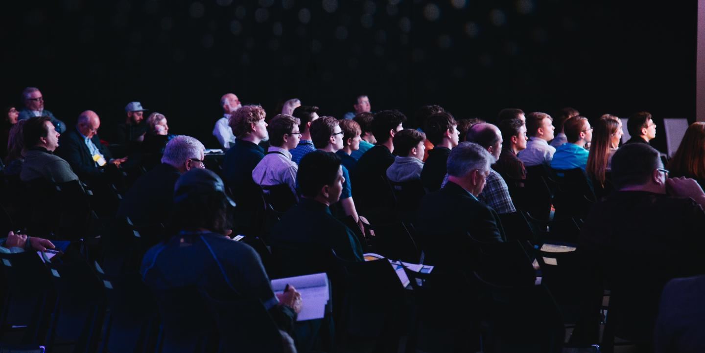 People listening to a speaker at a conference. 