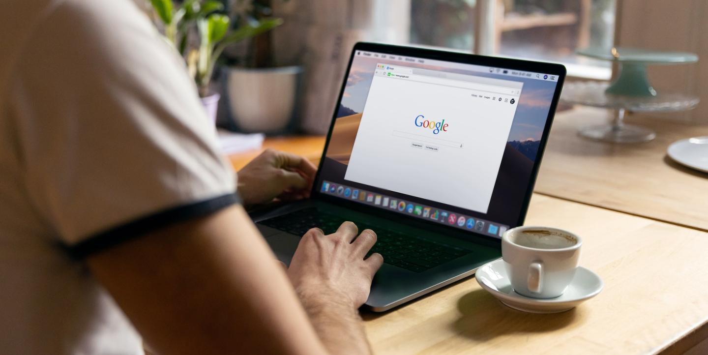 Человек на своем лаптопе ищет что-то с помощью поисковой системы Google 