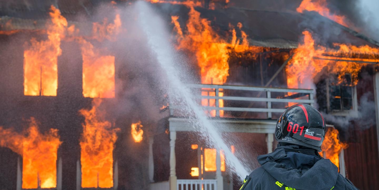 Un bombero intenta apagar las llamas de un edificio