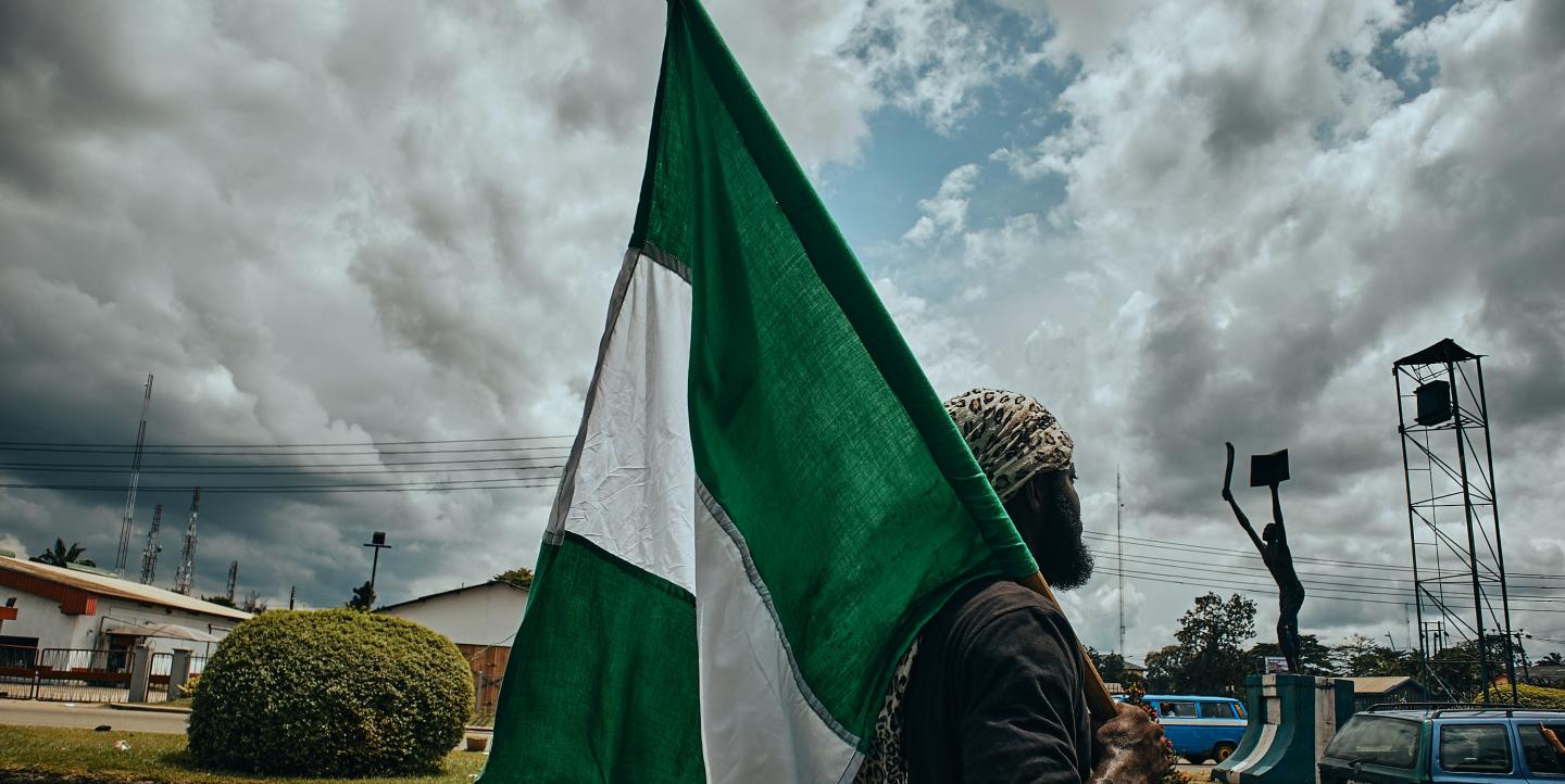 Hombre portando la bandera nigeriana verde y blanca