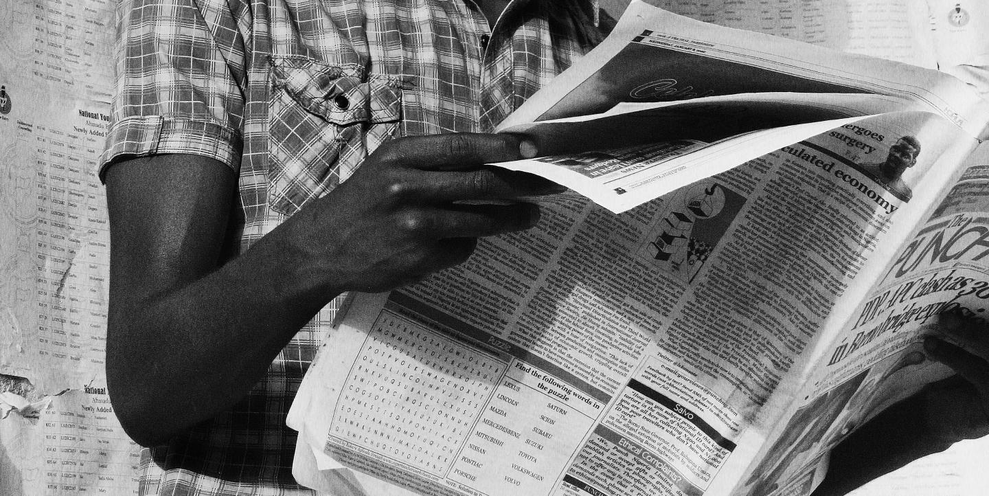Man reading newspaper in black and white