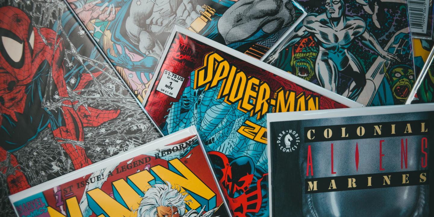 Different superhero comics piled together. 