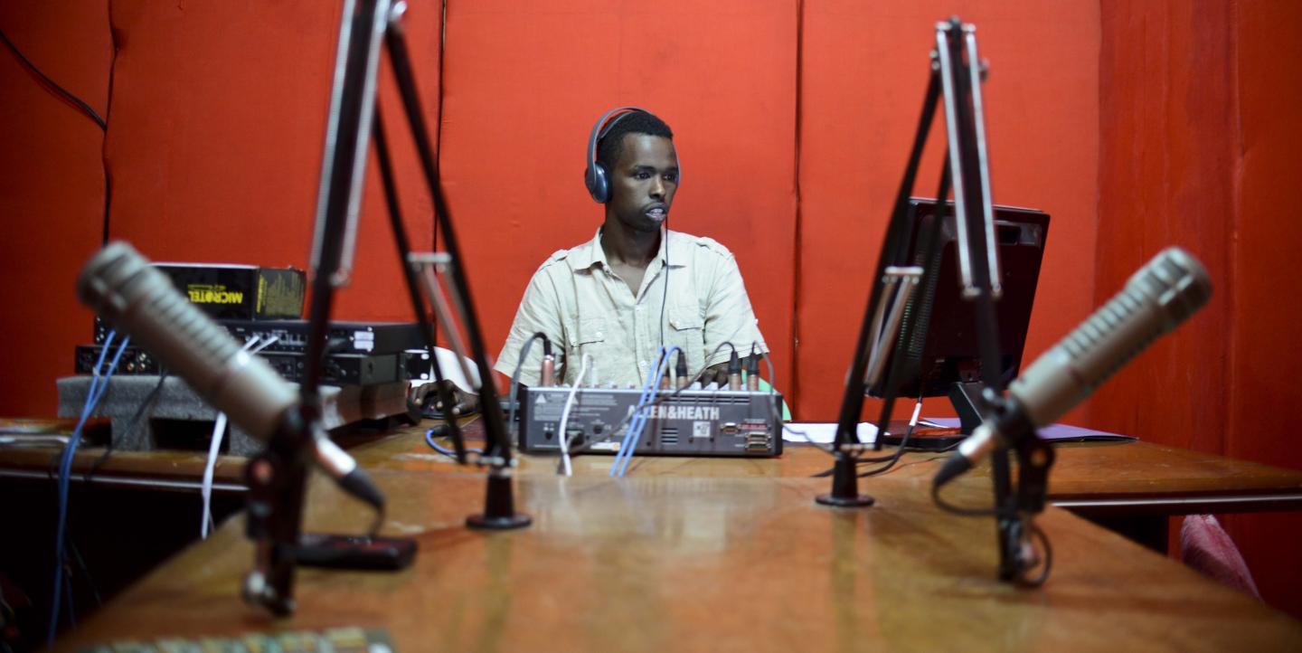 African man in a red recording studio booth