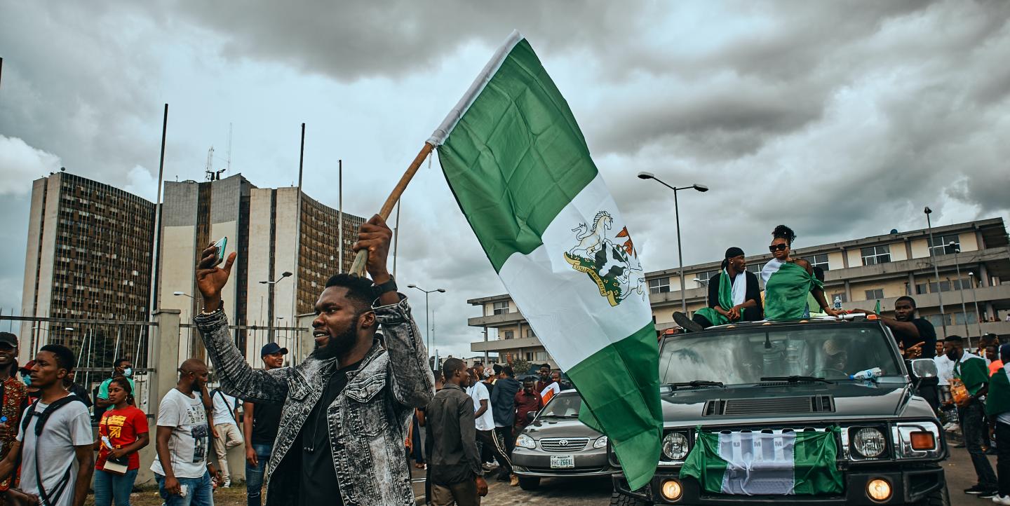A group of Nigerians holding flags and protesting. 