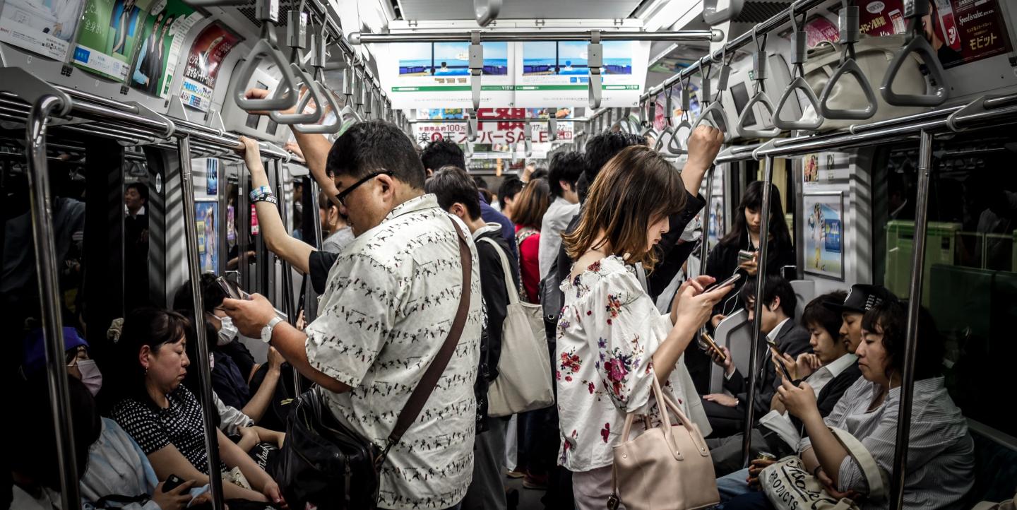Des personnes dans le métro, beaucoup lisent sur leur téléphone 