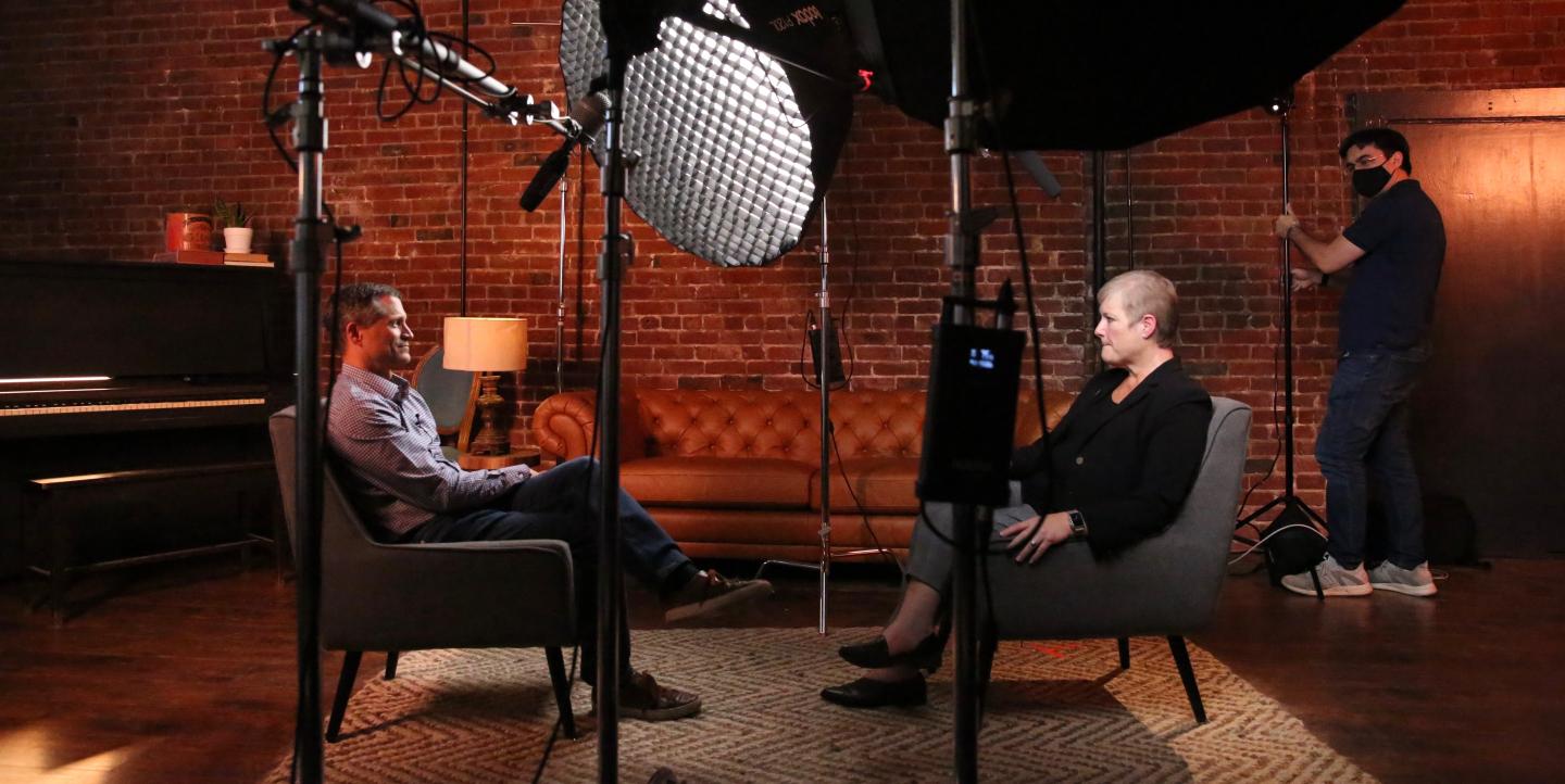 Un homme et une femme en interview TV dans un studio d'enregistrement