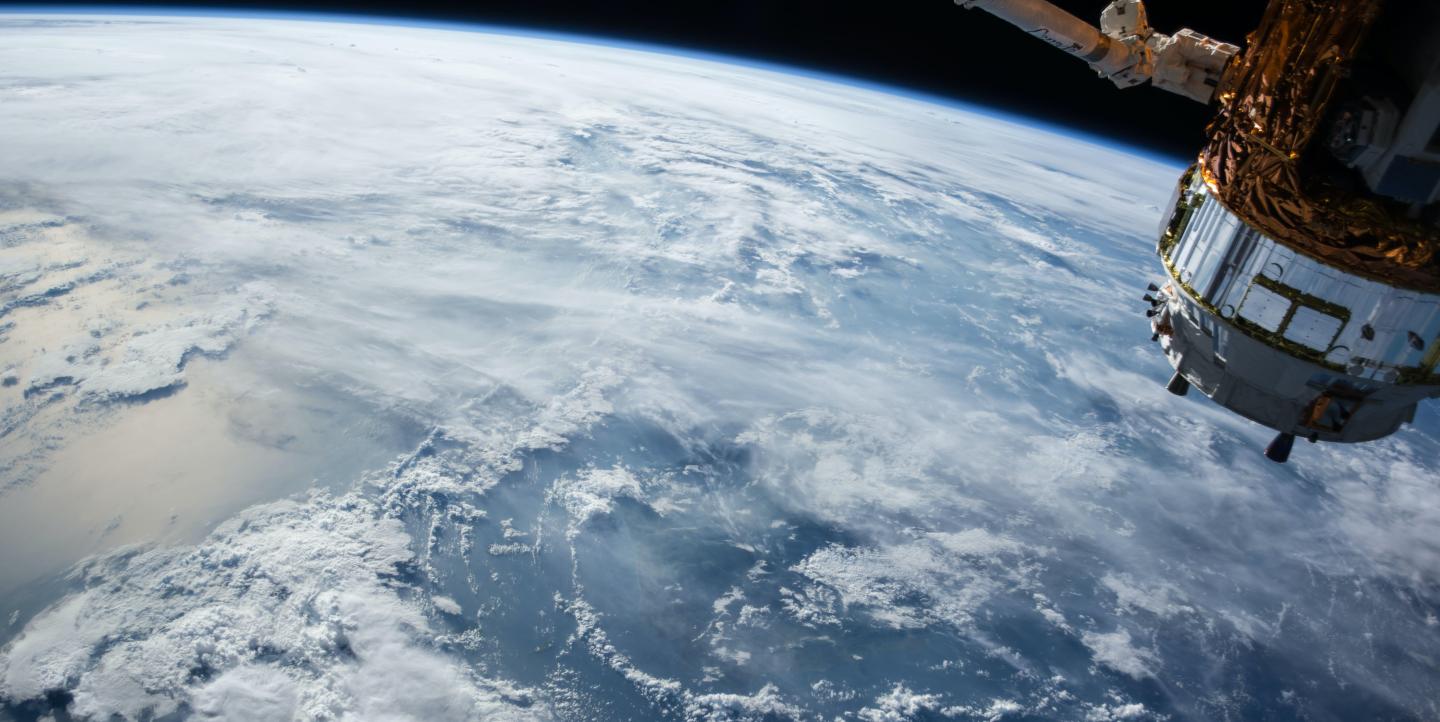 View of Earth from space, with a satellite in the corner of the frame