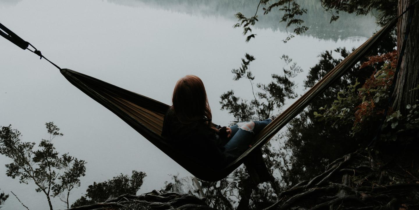 Woman in a hammock over a lake