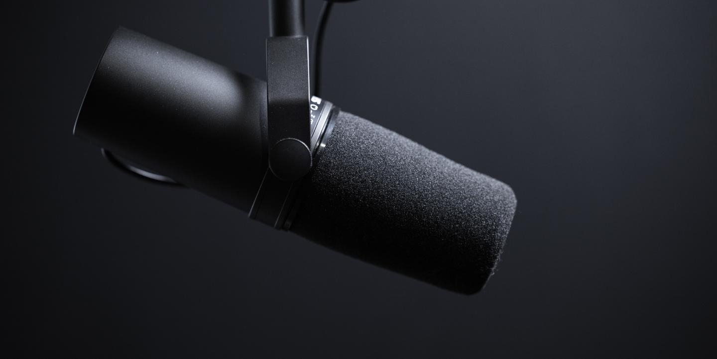 Micrófono negro sobre fondo negro.