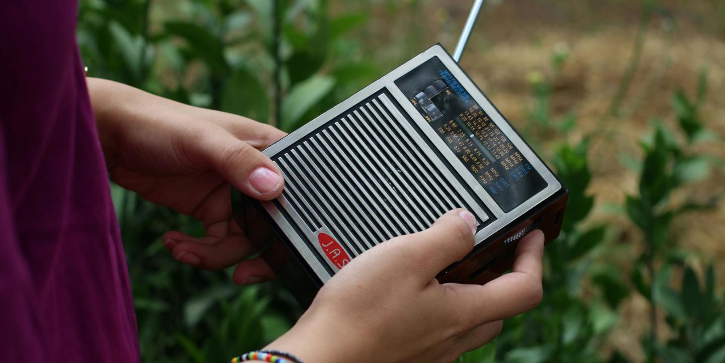 Person holding an old analog radio in their hands