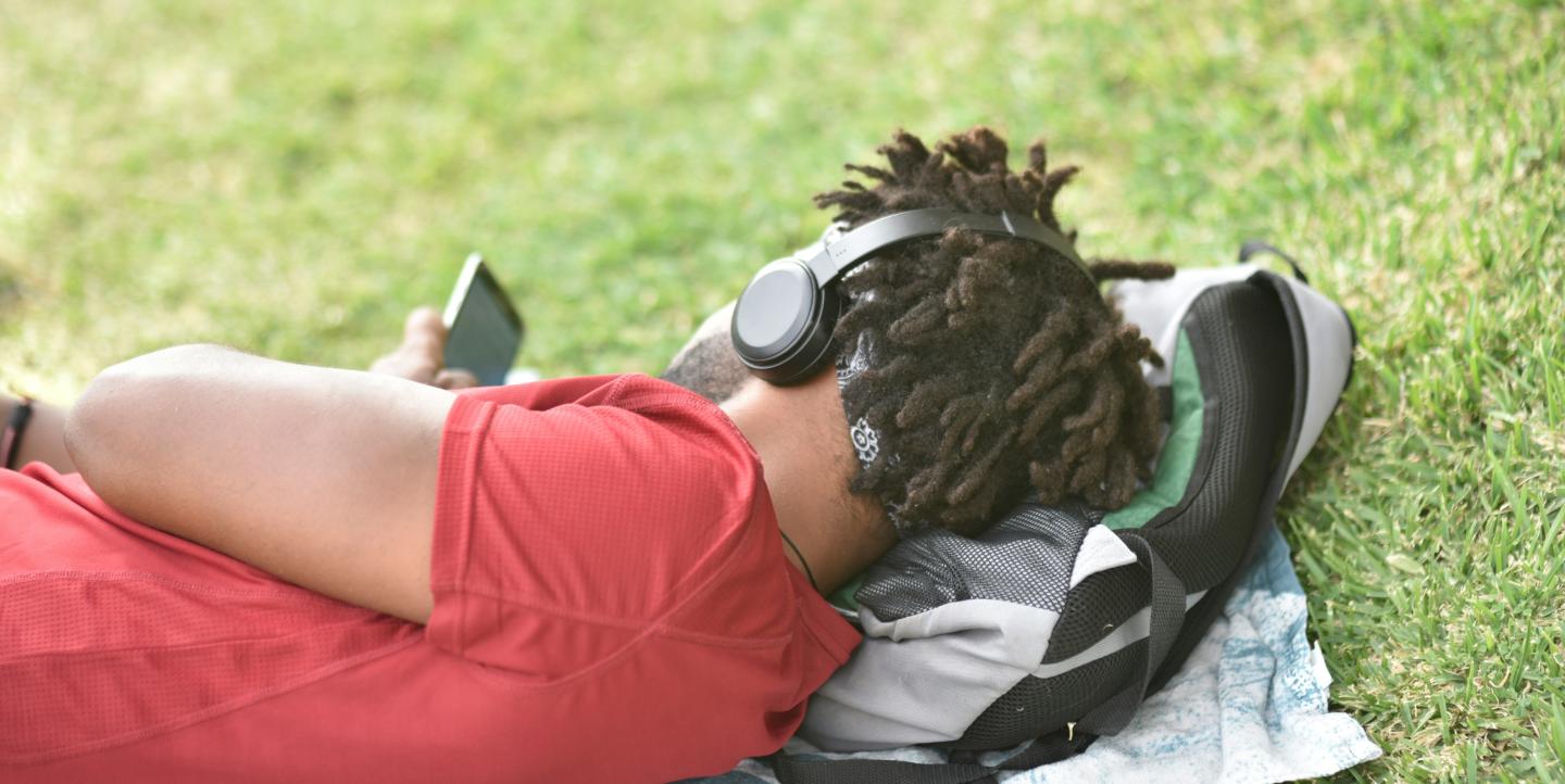 Un jeune allongé regarde son téléphone