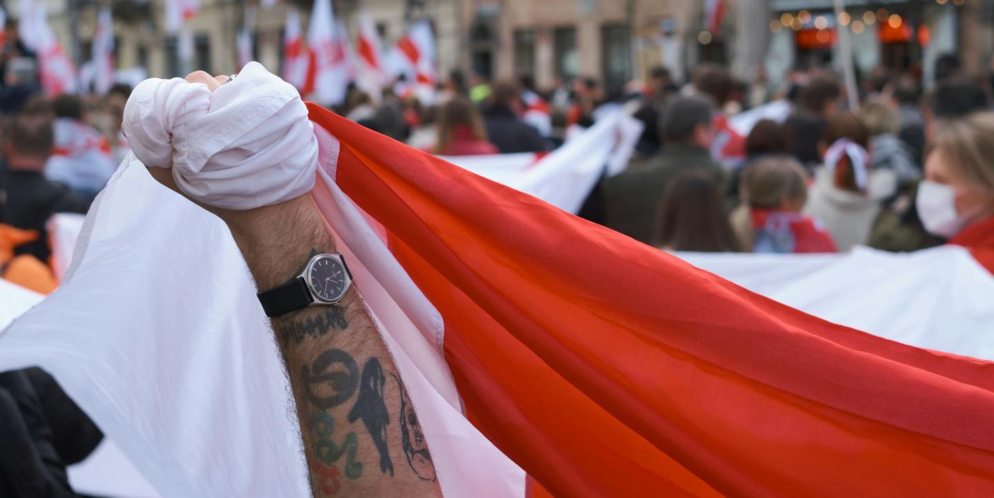 A man holding the national flag of Belarus, the march on Freedom Day of Belarus 2023 in Warsaw