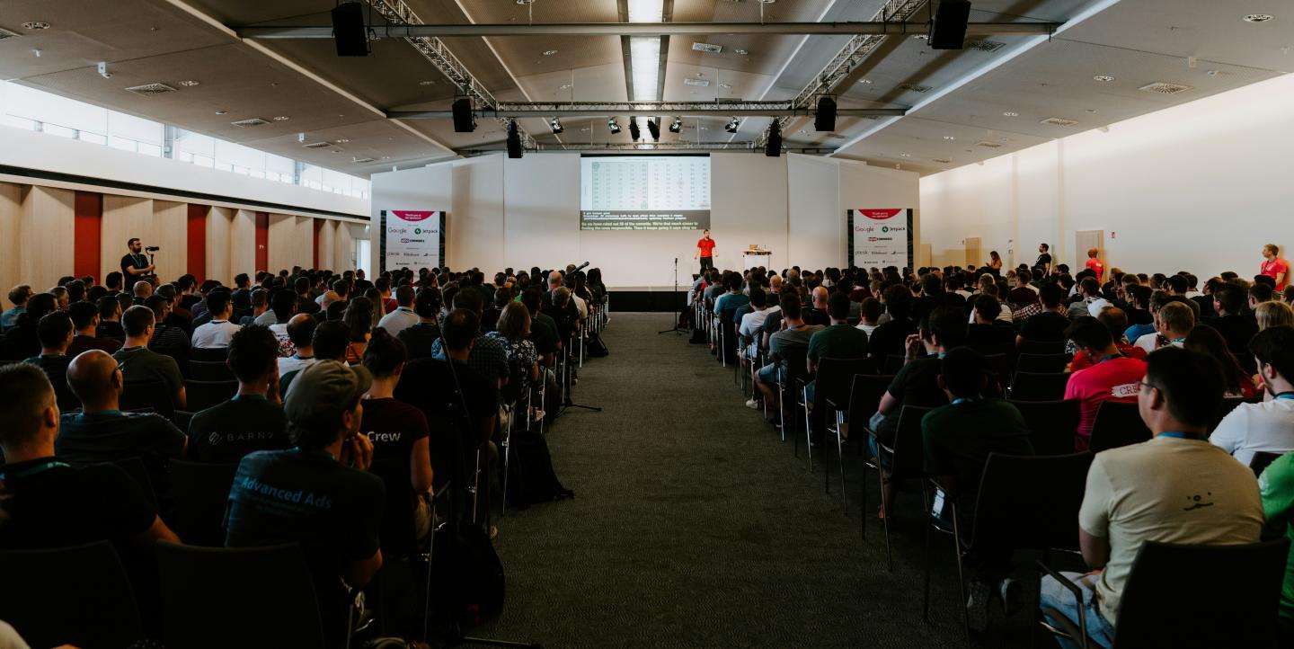 Un gran número de personas sentadas en una conferencia