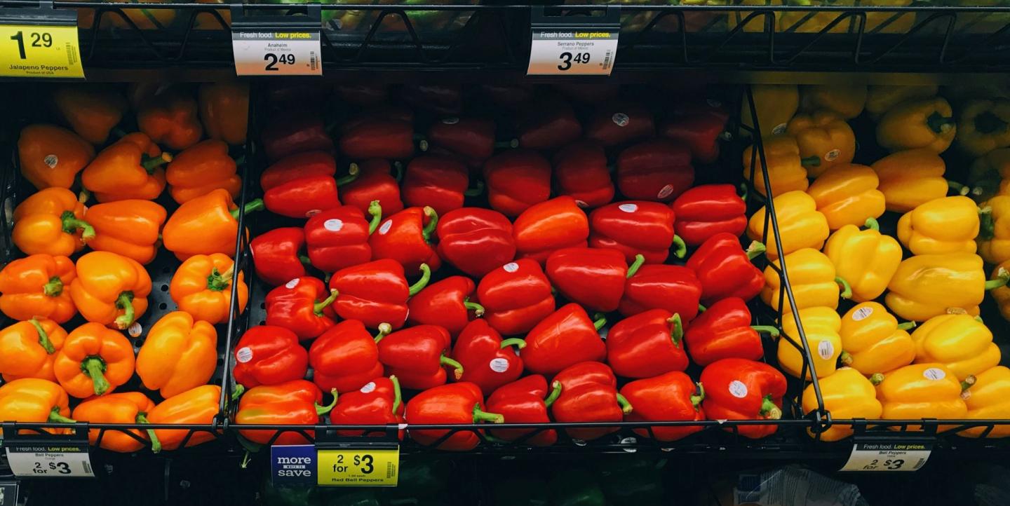 Bell peppers at a grocery store in red, orange, green and yellow