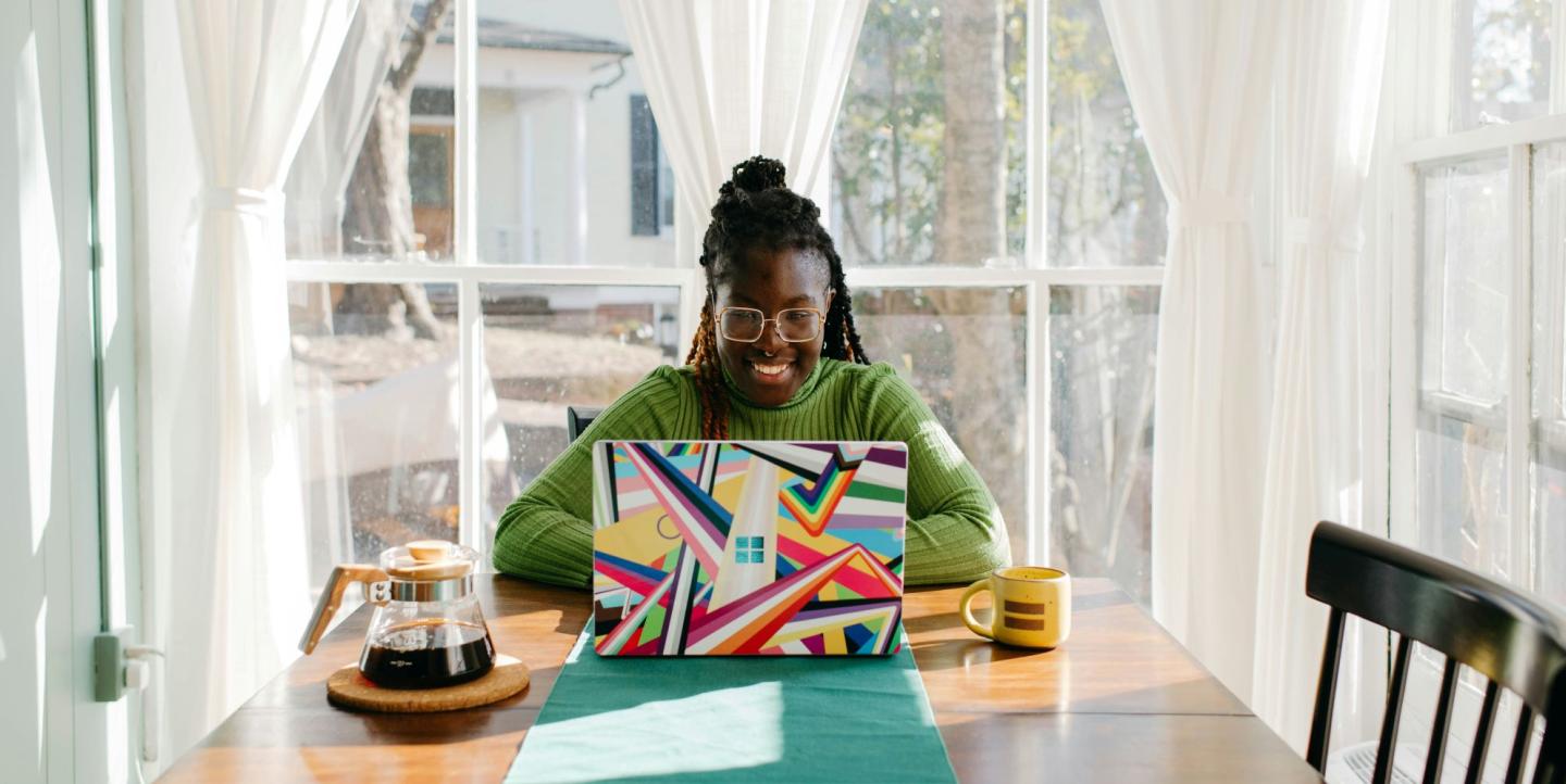 Mujer delante de una computadora colorida en una cocina bien iluminada