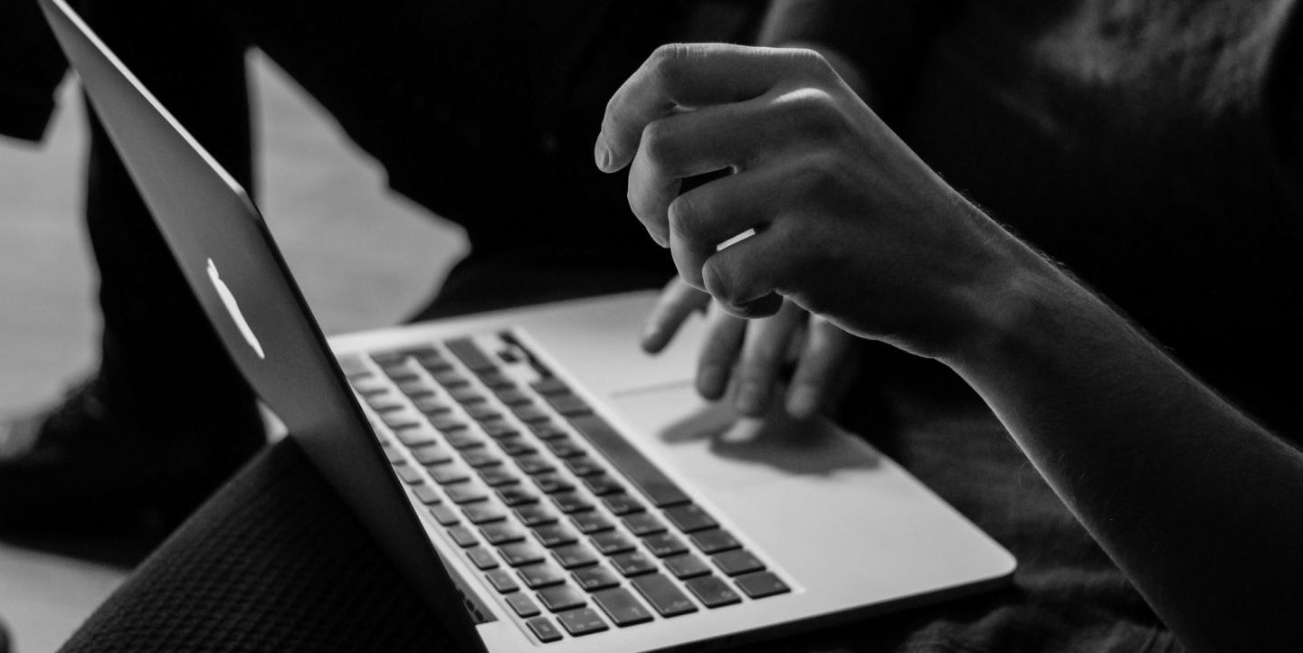 Black and white photo of a person on a computer