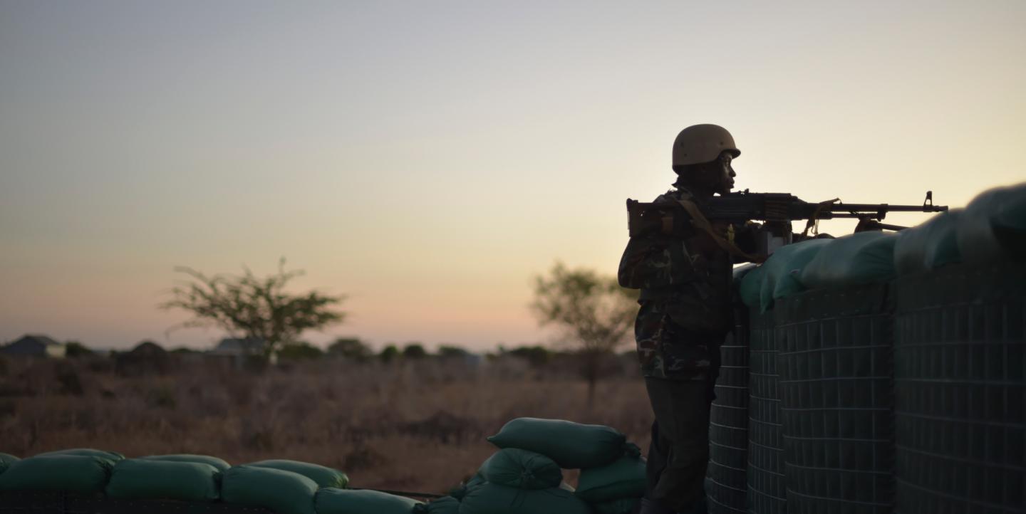 Soldat derrière une barricade au coucher du soleil