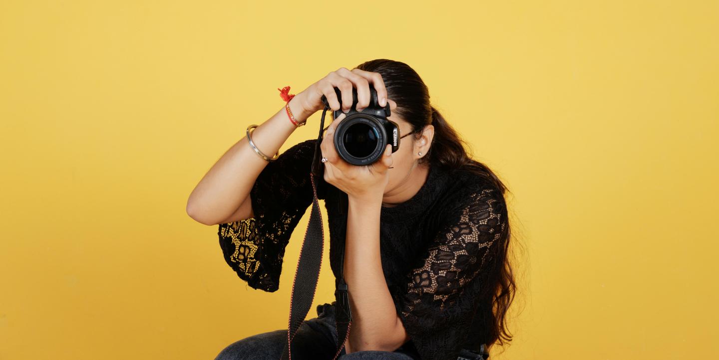 Femme photographe derrière son objectif