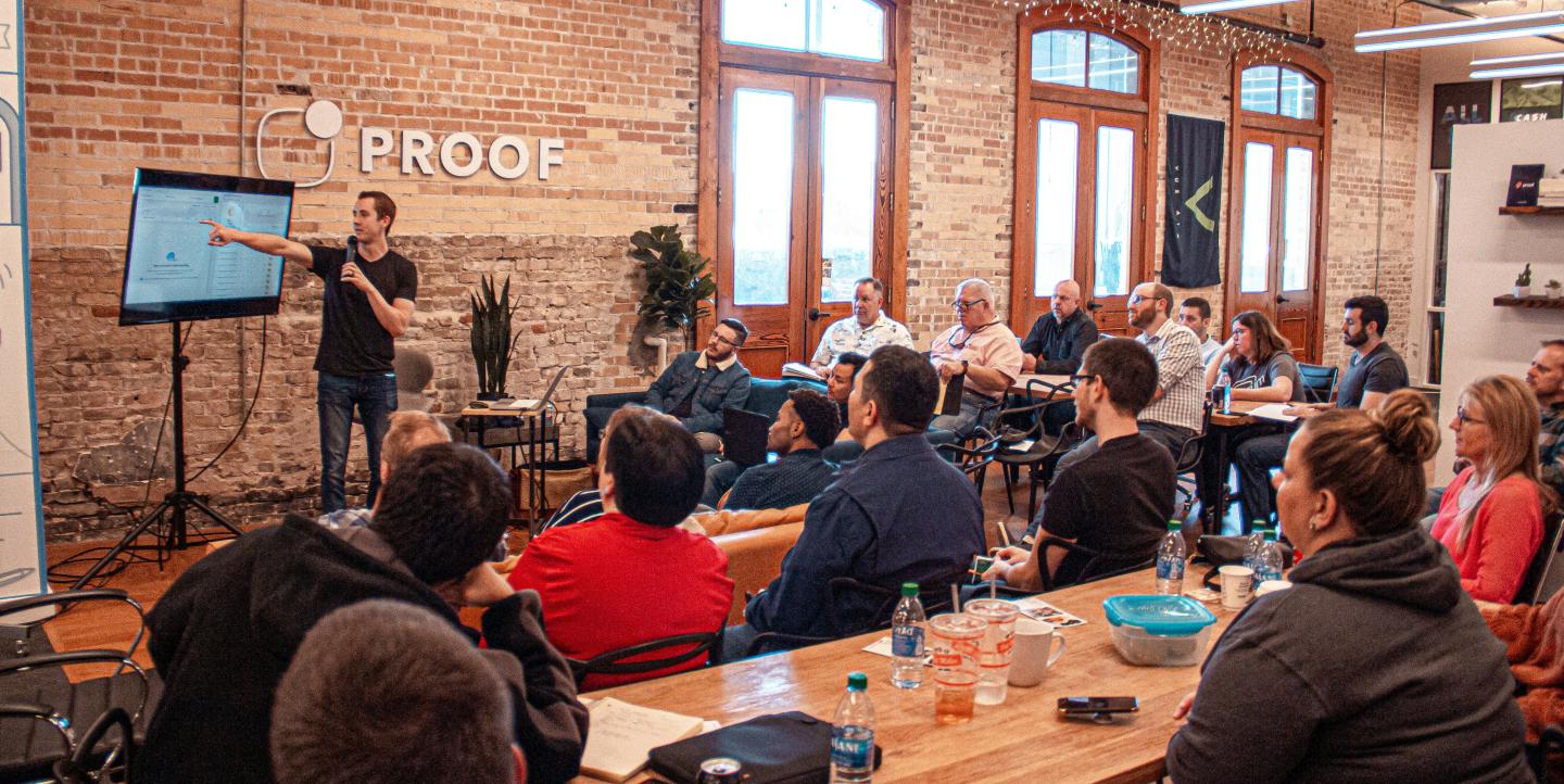 A man giving a presentation to audience of people.