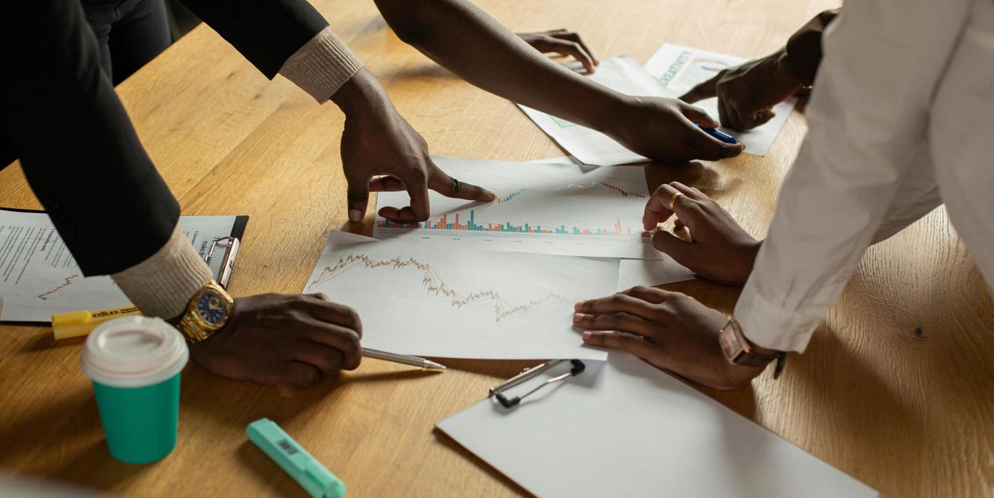Colleagues pointing to documents and graphs.