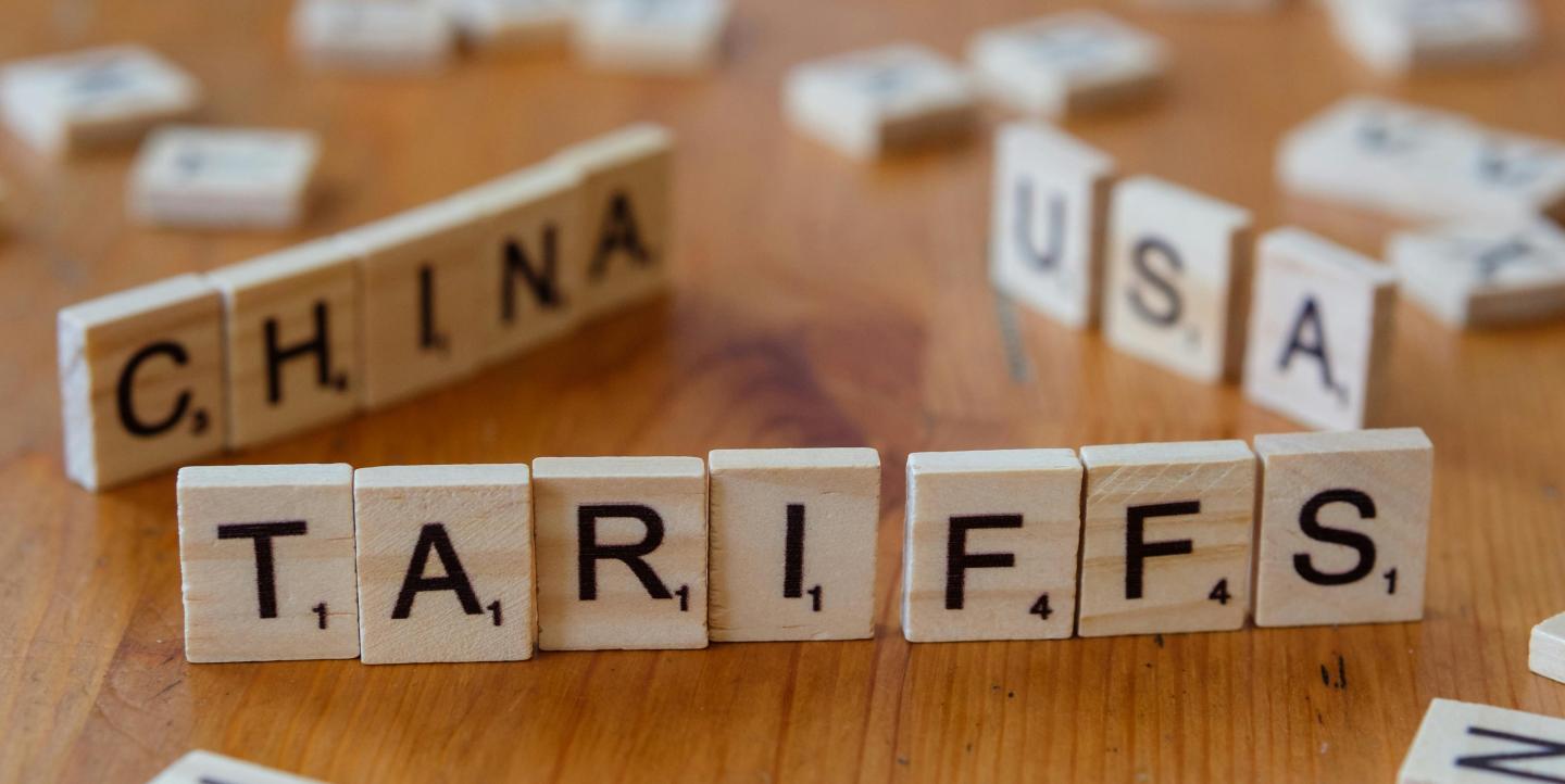 Scrabble pieces that spell out tariffs, china, USA.