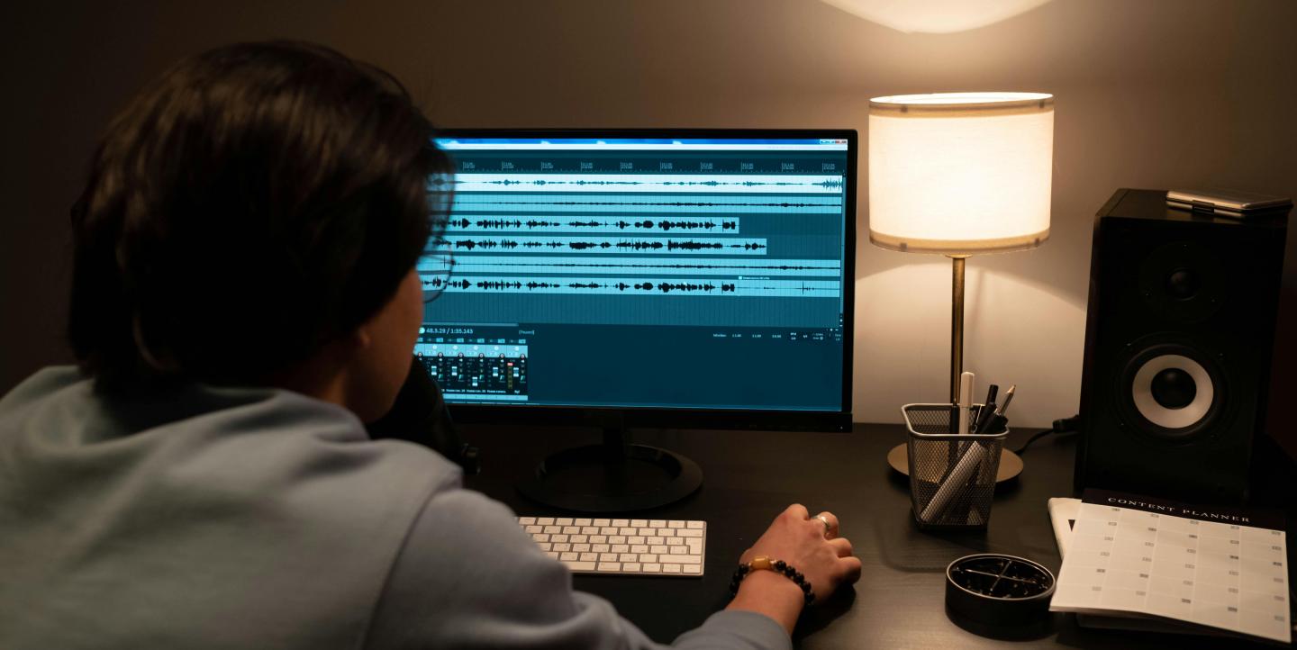 A woman reviewing audio files on her computer