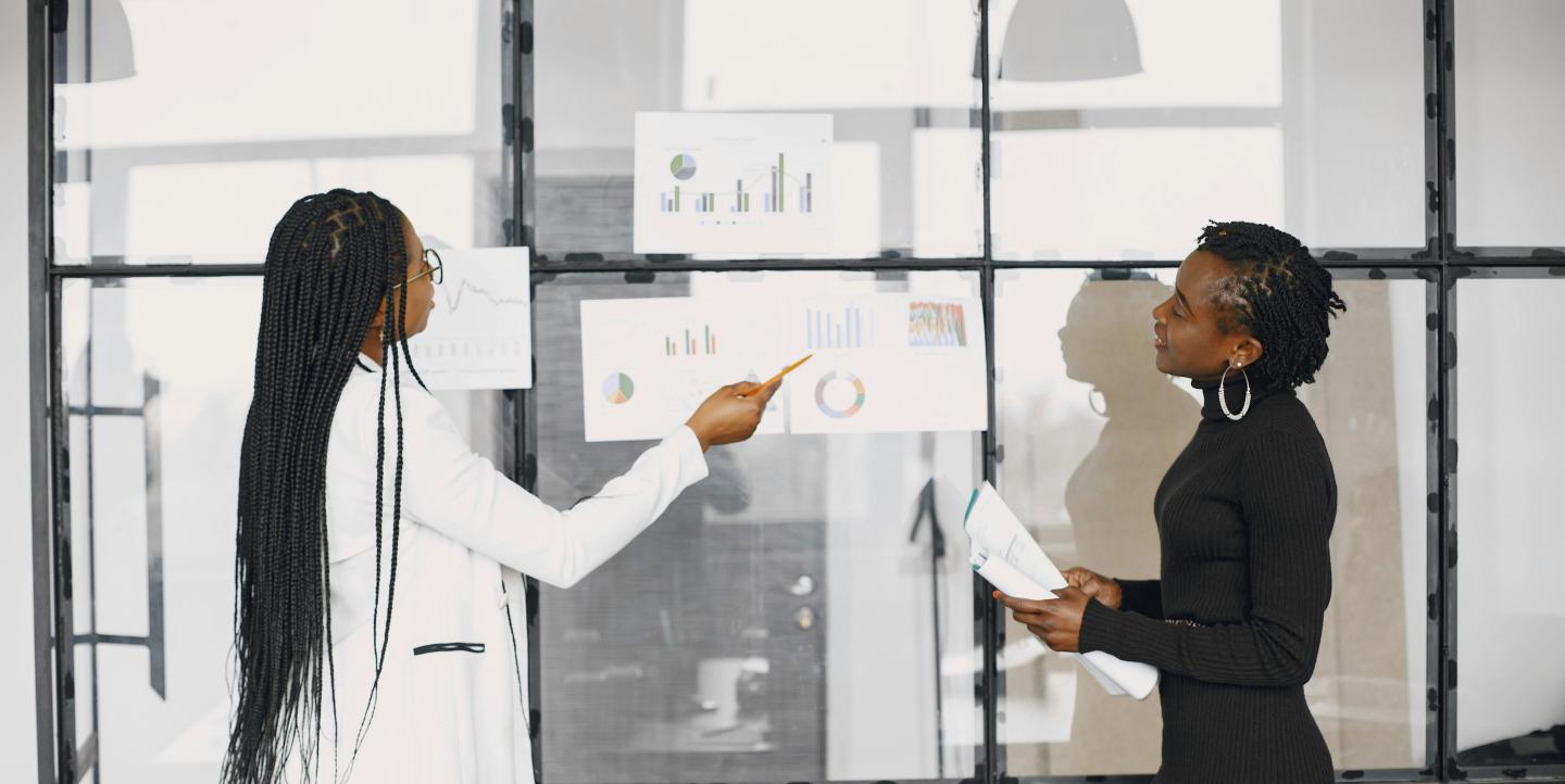 To women reviewing data and charts.