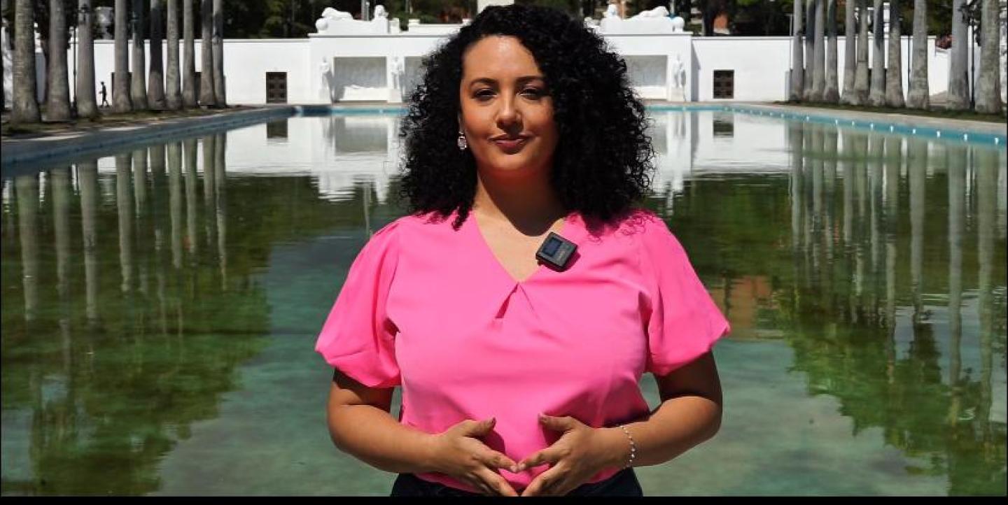 Ana frente a la cámara usando una blusa rosa