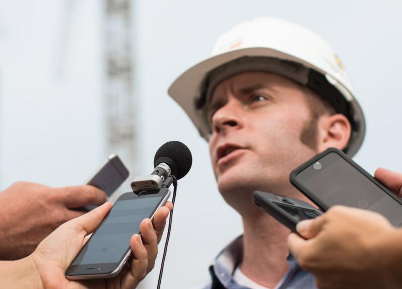Man surrounded by mics and smarphones