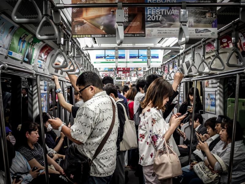 Des personnes dans le métro, beaucoup lisent sur leur téléphone