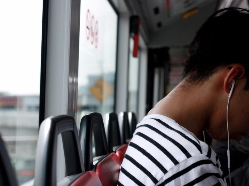 Une femme écoute un podcast dans un bus 
