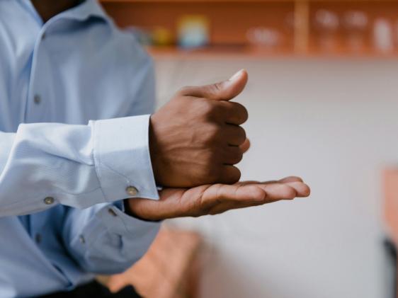 Un hombre hace señas de "ayuda" en lenguaje de señas